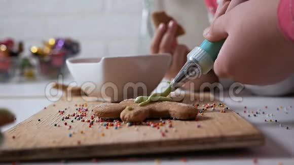 儿童手的特写装饰圣诞节生姜饼干为节日沙面图案视频的预览图