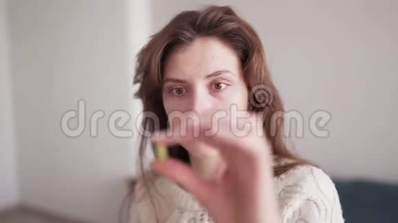 一位美丽的白种人妇女服用一种维生素丸看着它把它举在她的眼前卫生和医疗视频的预览图