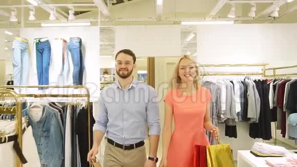 购物旅行年轻幸福的家庭带着购物离开商店慢动作视频的预览图