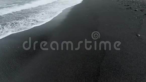 4k空中摄像机拍摄的黑色火山海滩及海浪翻滚视频的预览图