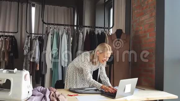 工作场所的快乐裁缝用手提电脑签一份利润丰厚的合同视频的预览图