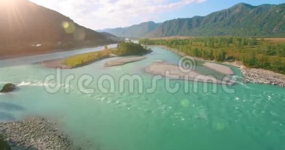 在阳光明媚的夏季早晨低空飞行在带岩石的新鲜快山河上视频的预览图