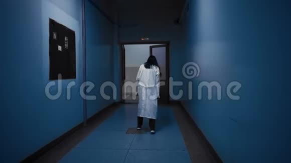 僵尸穿着白色外套走在黑暗的走廊上从后面看视频的预览图