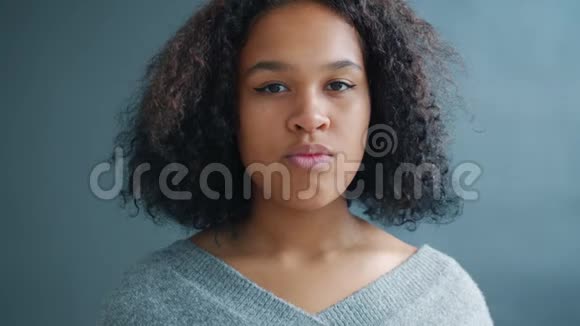 漂亮的非裔美国女孩用严肃的脸看镜头的肖像视频的预览图