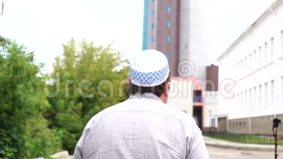 在城市行走的英俊穆斯林男子的后景视频的预览图