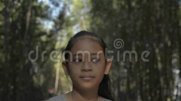 亚洲可爱的女孩在阳光下漫步在红树林的小径上视频的预览图