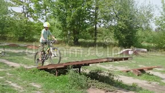 骑自行车的学生骑障碍平衡摇摆山地自行车视频的预览图