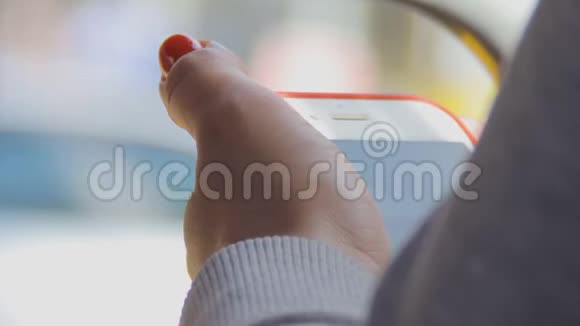 一个女人正在看一个小玩意的屏幕夏日阳光明媚公共交通视频的预览图