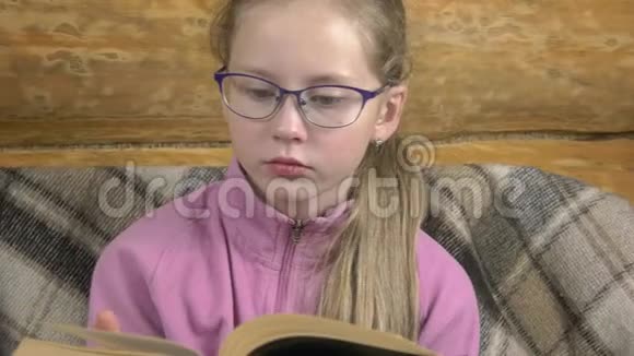 一个严肃的女孩正在读一本真正的纸质书视频的预览图