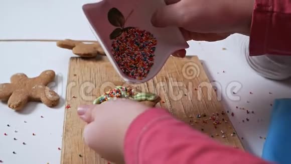 儿童手的特写装饰圣诞节生姜饼干为节日沙鼠图案甜美的色彩视频的预览图
