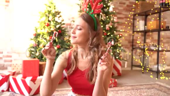 一个女人微笑着抱着的新年肖像心在甜蜜的焦糖棒的手中以拐杖的形式视频的预览图