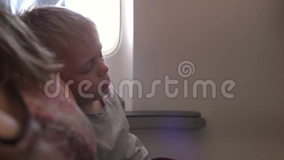 一个小男孩在飞机上睡觉的特写镜头慢动作视频的预览图