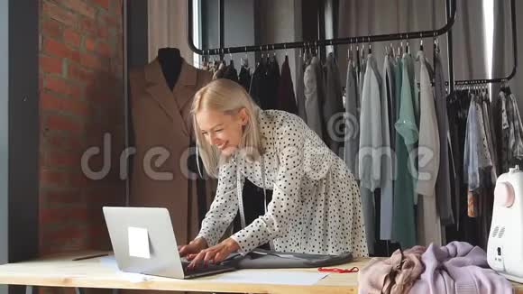 工作场所的快乐裁缝用手提电脑签订有利可图的合同视频的预览图