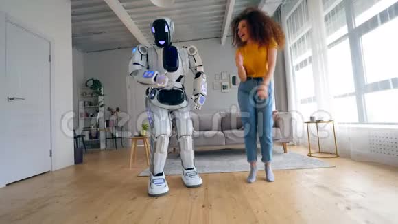 年轻的女人和一个机器人正在快乐地跳舞视频的预览图