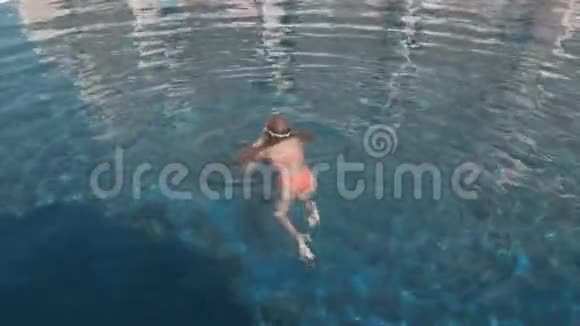 户外游泳池里穿泳装和护目镜的可爱女孩视频的预览图