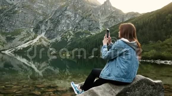 女游客使用手机为游客博客拍照或录制景观视频视频的预览图