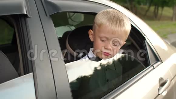 小男孩坐在汽车后座上看着窗外视频的预览图