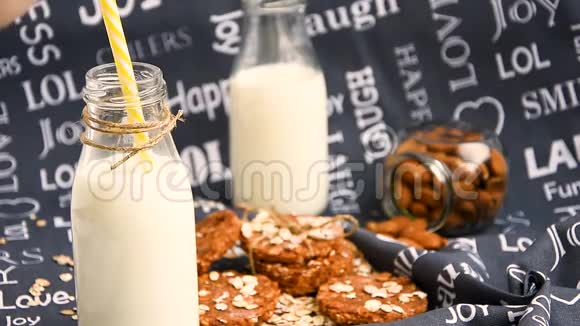 用吸管杯喝牛奶带背景饼干的老式瓶子视频的预览图
