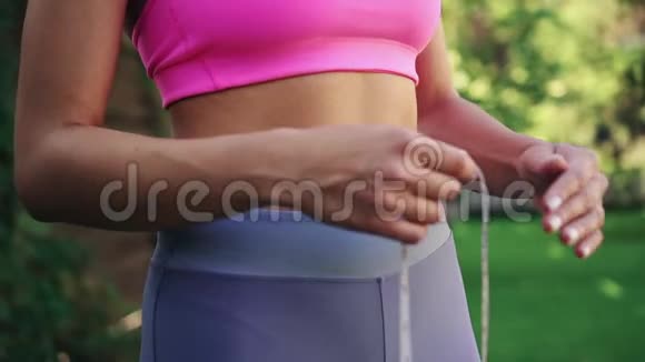 贴身女性手用胶带测量腰部瘦身概念视频的预览图