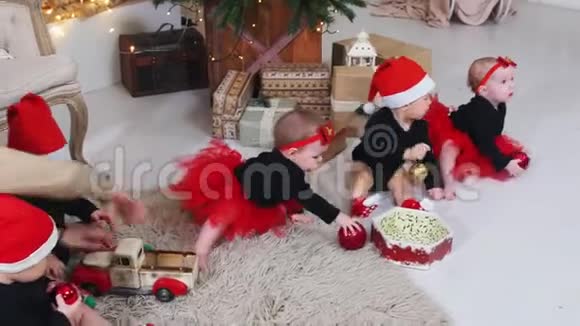 圣诞节概念小婴儿坐在地毯上玩圣诞球和玩具装饰视频的预览图