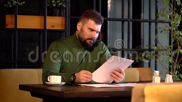 一个长胡子的商人在咖啡馆里的重要文件上签了字视频的预览图