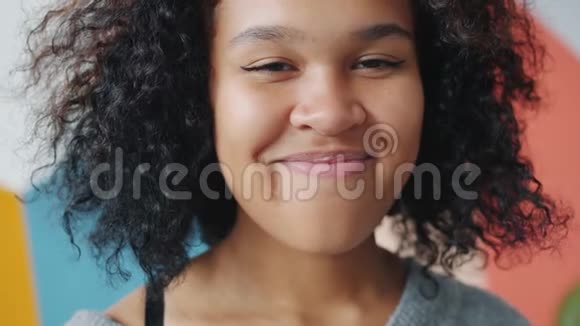 漂亮的非裔美国学生微笑着看镜头的慢镜头肖像视频的预览图
