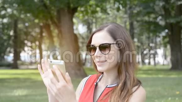 一个年轻女孩在一个夏天公园的视频通话视频的预览图