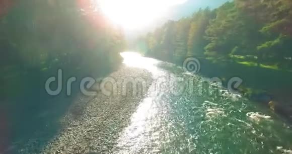 在阳光明媚的夏季早晨低空飞行在带岩石的新鲜快山河上视频的预览图