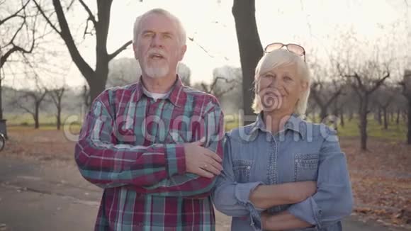 高加索族夫妻站在秋天公园的阳光下对着镜头说话成熟的欧洲夫妇视频的预览图
