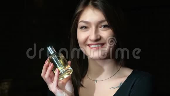 一个带香水瓶的漂亮女孩的肖像视频的预览图