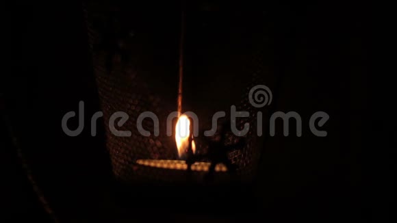 在黑色背景下燃烧的网状豆荚中的蜡烛视频的预览图