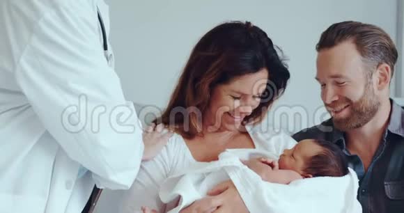 高加索夫妇的正面景色医生在医院病房里抱着他们的新生儿视频的预览图