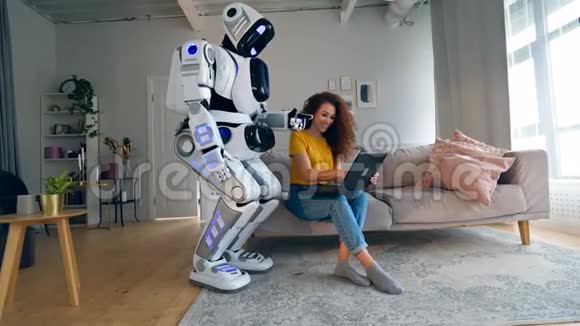年轻女子正在操作一台笔记本电脑正在咨询一个机器人视频的预览图