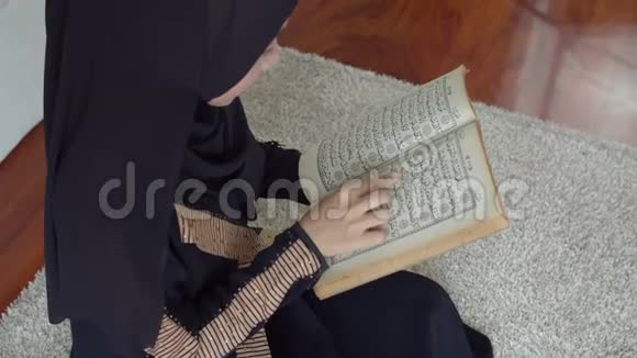 穿着伊斯兰服装读古兰经的年轻穆斯林女性视频的预览图