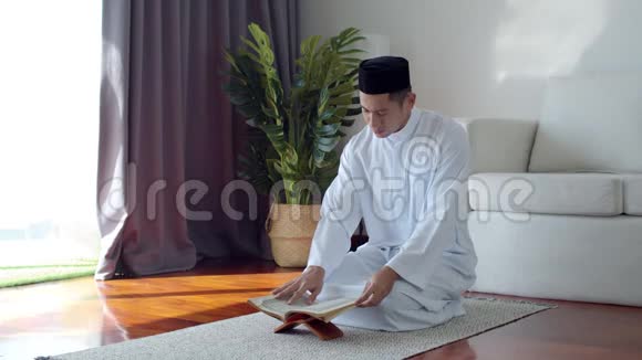 穿着伊斯兰服装读古兰经的穆斯林青年视频的预览图