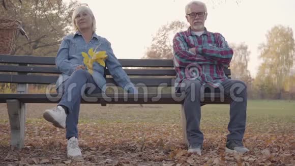 欧洲资深夫妇分别坐在长凳上成熟的白种人男人牵着他可爱的妻子家人视频的预览图