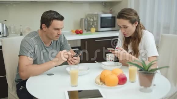 快乐的一对夫妇在健康的早餐中看手机视频的预览图