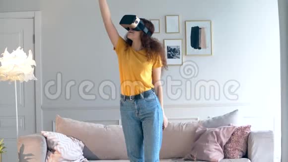 年轻女子移动手臂同时佩戴VR设备视频的预览图