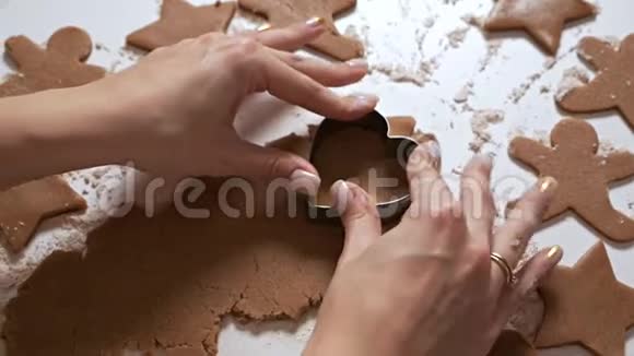 家庭主妇做圣诞饼干女人用生面团做了一个心形姜饼视频的预览图