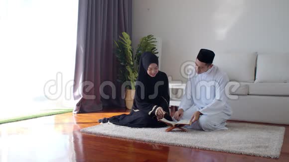 英俊的穆斯林男子教年轻女子读古兰经视频的预览图