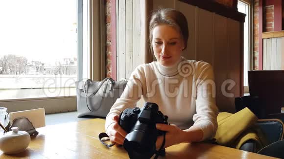 有摄像机的女人坐在咖啡馆里视频的预览图