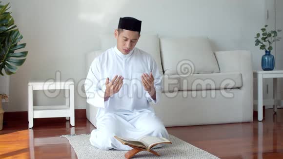 年轻的穆斯林穿着伊斯兰服装读着古兰经祈祷视频的预览图