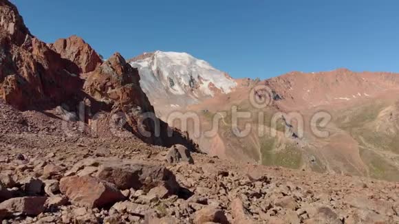 徒步旅行者背着背包站在山上的一块大石头上视频的预览图