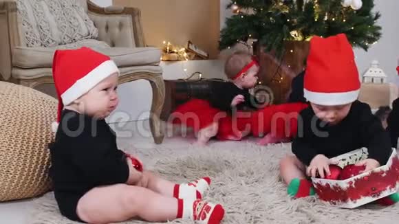 圣诞节概念小宝宝坐在地毯上在装饰好的工作室里玩圣诞球视频的预览图