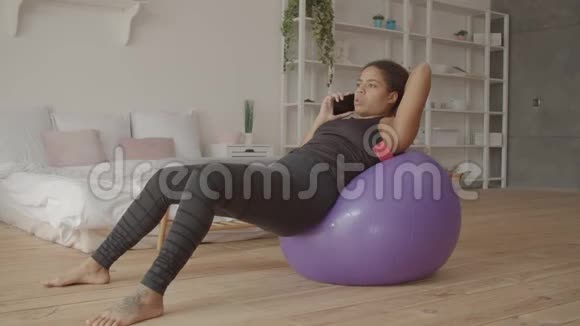放松的女人在锻炼后用手机聊天视频的预览图