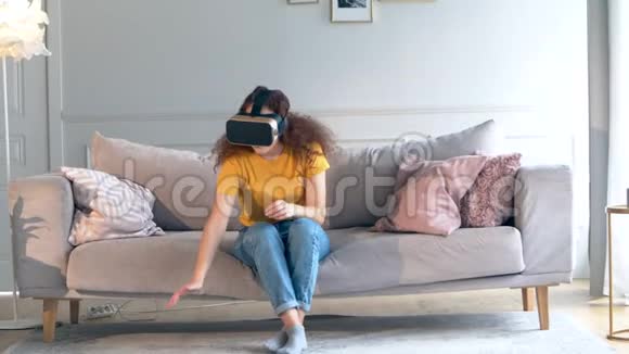 一个戴着VR眼镜的女孩正在移动双手站起来视频的预览图