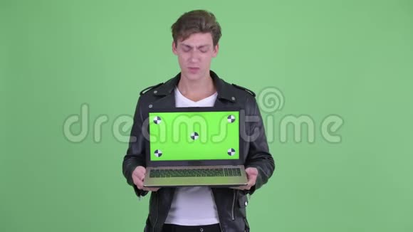 穿着衣服的叛逆青年展示笔记本电脑视频的预览图