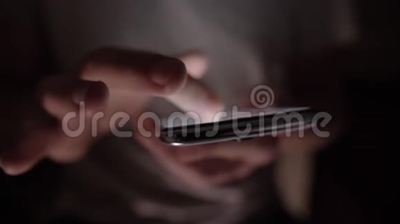 男人的手在屏幕上滚动从手机上发出明亮的眩光合上失去焦点视频的预览图
