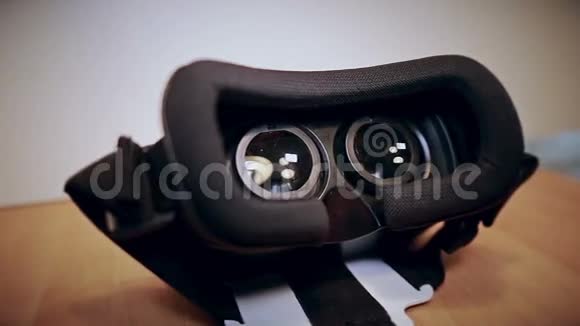 摄像机在虚拟现实眼镜周围缓慢移动vr躺在桌子上从不同的侧面观看视频的预览图