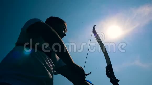 鲍曼在阳光下拉着弓弦用弓箭射击视频的预览图